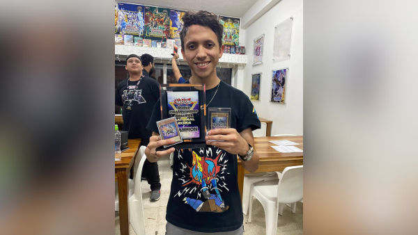 Eduardo Vega pose felizmente junto con sus recompensas por convertirse en campeón.