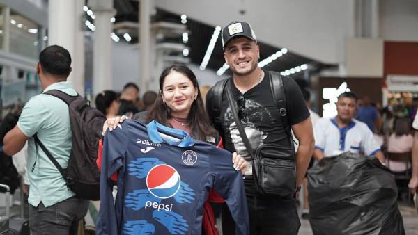 Una aficionada sacó de su maleta una camisa del Motagua para mostrarsela a Rocca ya que lo quiere ver en el Ciclón. FOTO: Mauricio Ayala