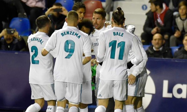 Real Madrid's defender Sergio Ramos (C) celebrates with teammtes after scoring during the Spanish league football match between Levante UD and Real Madrid CF at the Ciutat de Valencia stadium in Valencia on February 03, 2018. / AFP PHOTO / JOSE JORDAN