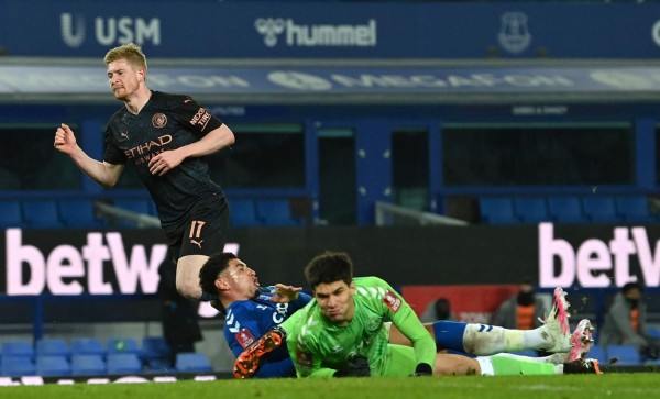 Manchester City's Belgian midfielder Kevin De Bruyne (L) watches the ball go into the net as he scores his team's second goal past Everton's English midfielder Ben Godfrey (C) and Everton's Portuguese goalkeeper Joao Virginia (R) during the English FA Cup quarter final football match between Everton and Manchester City at Goodison Park in Liverpool, north west England on March 20, 2021. (Photo by Paul ELLIS / POOL / AFP) / RESTRICTED TO EDITORIAL USE. No use with unauthorized audio, video, data, fixture lists, club/league logos or 'live' services. Online in-match use limited to 120 images. An additional 40 images may be used in extra time. No video emulation. Social media in-match use limited to 120 images. An additional 40 images may be used in extra time. No use in betting publications, games or single club/league/player publications. /