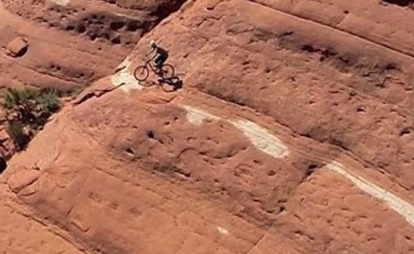 Con un drone graban a ciclista que sube en su bicicleta a un risco