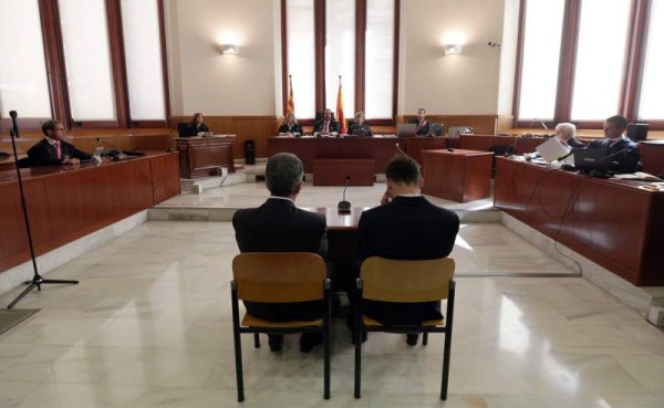 Messi en el banquillo de los acusados junto a su padre. Fotos AFP.
