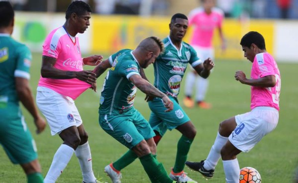 Carlos Pineda en el partido ante Platense intenta quitarle la pelota a Jorge Cardona quien sujeta de la camisa al delantero Carlo Costly. Foto Juan Salgado