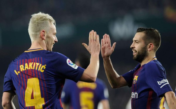 Barcelona's Croatian midfielder Ivan Rakitic (L) celebrates with Barcelona's Spanish defender Jordi Alba after scoring a goal during the Spanish league football match between Real Betis and FC Barcelona at the Benito Villamarin stadium in Sevilla on January 21, 2018. / AFP PHOTO / CRISTINA QUICLER