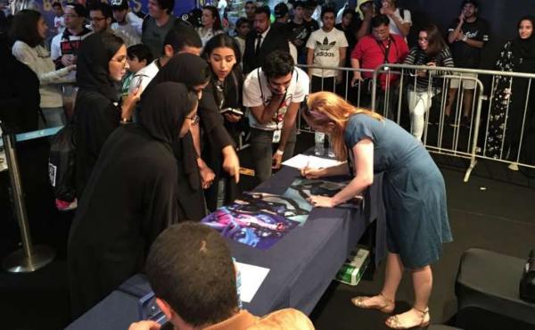 Chloé firmando felizmente autógrafos para sus fans durante un evento. <b>Foto:</b> Inven Global.