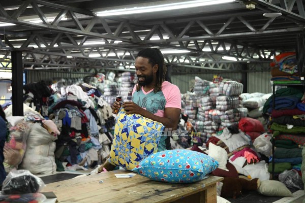 Así es el trabajo de Roy Smith cargando bultos y seleccionando ropa en una bodega de ropa