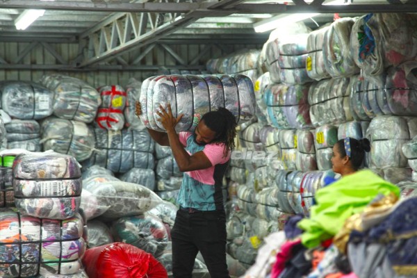Así es el trabajo de Roy Smith cargando bultos y seleccionando ropa en una bodega de ropa