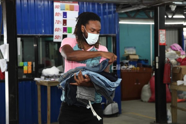 Así es el trabajo de Roy Smith cargando bultos y seleccionando ropa en una bodega de ropa
