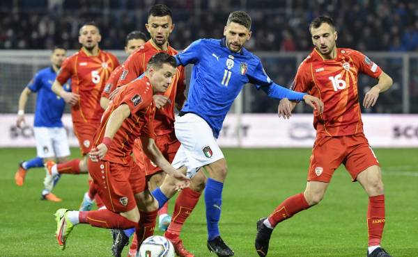 El defensor de Macedonia del Norte, Ezgjan Alioski (L), desafía al delantero de Italia, Domenico Berardi (C), durante el partido de fútbol clasificatorio para la Copa Mundial 2022 entre Italia y Macedonia del Norte.