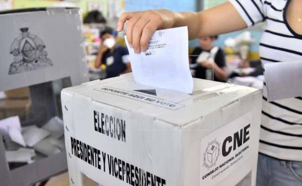Momento en que los ciudadanos de Honduras extienden su voto.