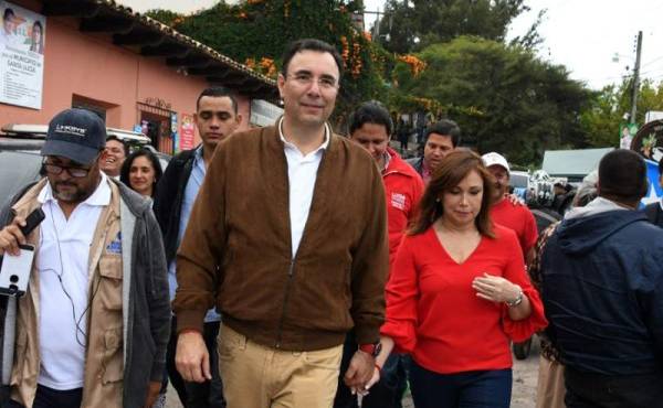 The presidential candidate of the opposition Liberal Party Luis Zelaya (C), accompained by his wife Ana Lucia, leaves after casting his vote at polling station in Santa Lucia municipality, 11 kilometres east of Tegucigalpa, during the general election on November 26, 2017.Honduras' six million voters are to cast ballots in a controversial election Sunday in which President Juan Orlando Hernandez is seeking a second mandate despite a constitutional one-term limit. This small country is at the heart of Central America's 'triangle of death,' an area plagued by gangs and poverty. / AFP PHOTO / ORLANDO SIERRA
