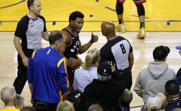 $!OAKLAND, CALIFORNIA - JUNE 05: Kyle Lowry #7 of the Toronto Raptors complains to referee Marc Davis #8 after being pushed by Warriors minority investor Mark Stevens (blue shirt, seated) in the second half against the Golden State Warriors during Game Three of the 2019 NBA Finals at ORACLE Arena on June 05, 2019 in Oakland, California. According to to the Warriors, Stevens will not be in attendance for the remainder of the NBA Finals as they look further into the incident. NOTE TO USER: User expressly acknowledges and agrees that, by downloading and or using this photograph, User is consenting to the terms and conditions of the Getty Images License Agreement. Lachlan Cunningham/Getty Images/AFP