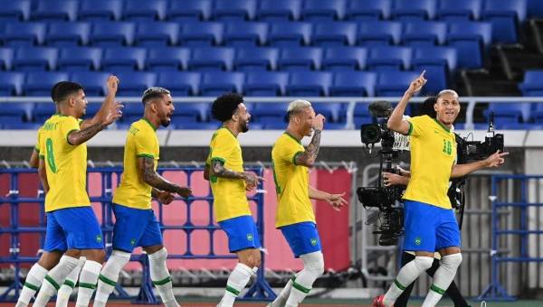 Brazil's forward Richarlison (R) celebrates with teammates after opening the scoring during the Tokyo 2020 Olympic Games men's group D first round football match between Brazil and Germany at the Yokohama International Stadium in Yokohama on July 22, (Photo by DANIEL LEAL-OLIVAS / AFP)
