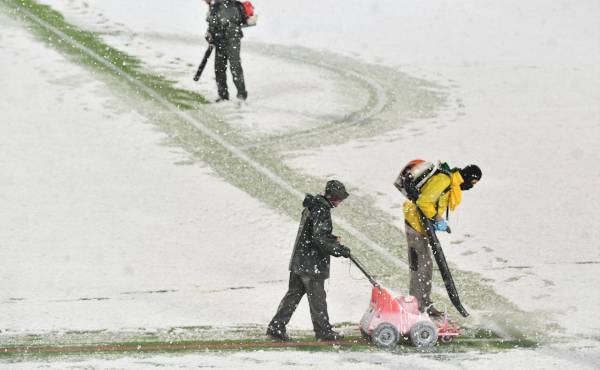 $!Trabajadores del estadio Gewiss Stadium en Bérgamo, Italia, intentan retirar la nieve, pero la intensa tormenta continuó.