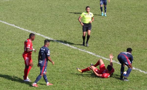 Jonathan Núñez intenta jugar rápido ante la mirada del árbitro Selvin Brown. Foto: Dagoberto Luján.