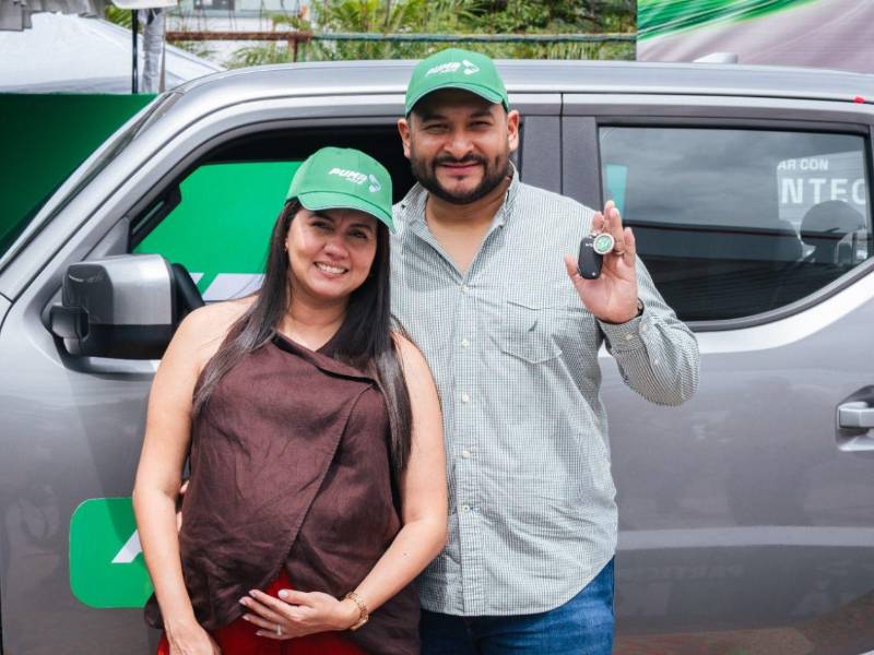Angelo Meléndez y su esposa celebran frente al KIA Tasman al recibir las llaves del vehículo que ganó en la promoción “Ahorrá y Ganá”.