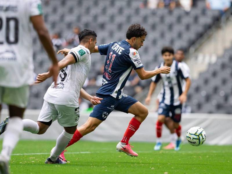 El hondureño Carlos Pineda persigue a un jugador de Rayados de Monterrey durante el partido amistoso que se disputó en territorio mexicano.