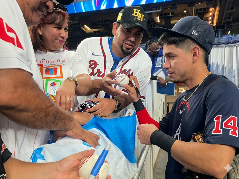 El pelotero hondureño, Mauricio Dubón, firmando bandera y pelotas a sus compatriotas en Miami, Florida.