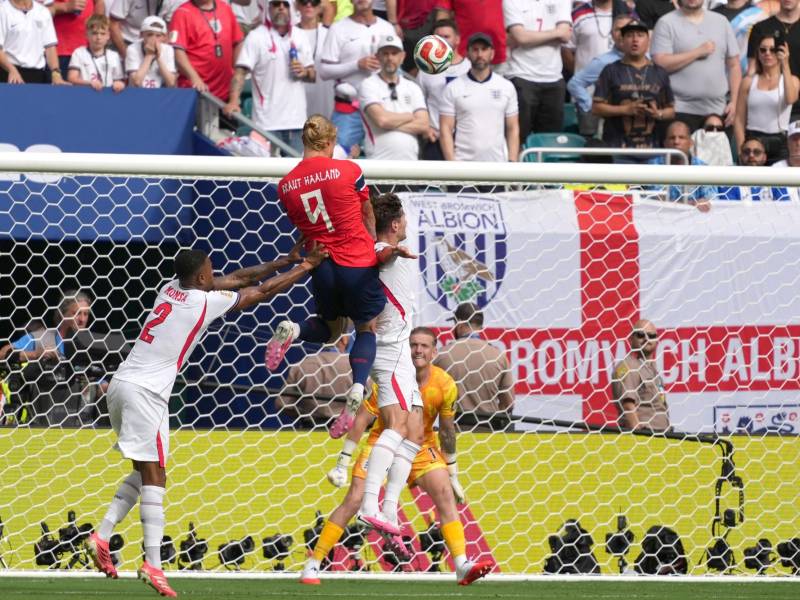 Erling Haaland de Noruega disputa el balón con Ezri Konsa (i) y John Stones de Inglaterra durante el partido de cuartos de final del Mundial de la FIFA.
