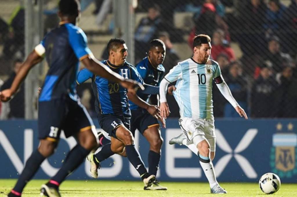 Jorge Claros y Beckeles intentan quitarle el balón a Messi en el último juego que han disputado Argentina y Honduras.